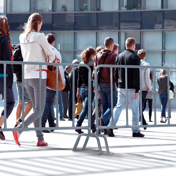 A group of people walking through an AdirPro steel barricade.