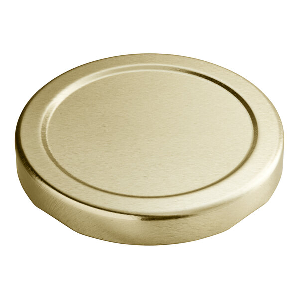 A close up of a 63 mm gold metal lid with a plastisol liner.