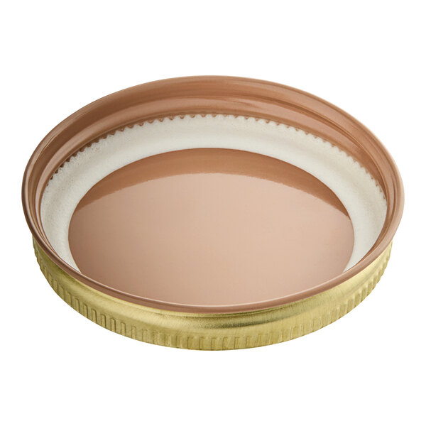 A close-up of a 58/400 gold metal lid with a plastisol liner.