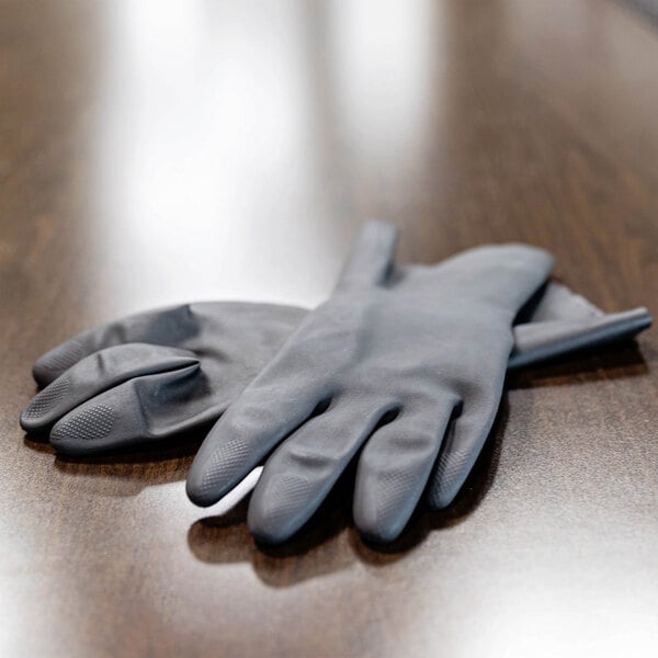 A pair of black industrial-grade rubber gloves with flock lining.