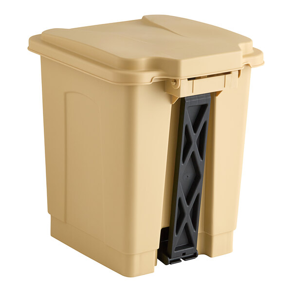 A tan plastic trash can with a black handle.