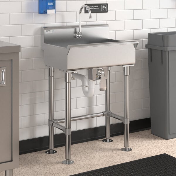 A Regency stainless steel hand sink with knee-operated faucet over a pipe.