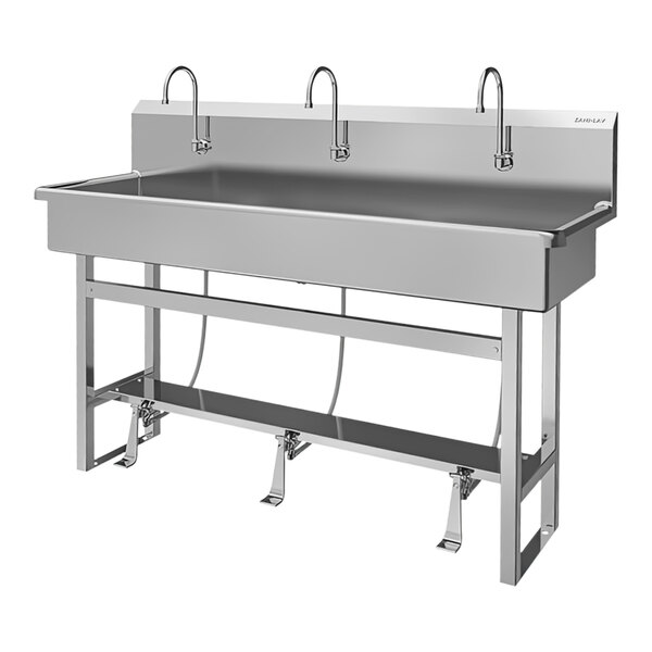 A stainless steel Sani-Lav floor-mounted multi-station sink with (3) foot-operated faucets.