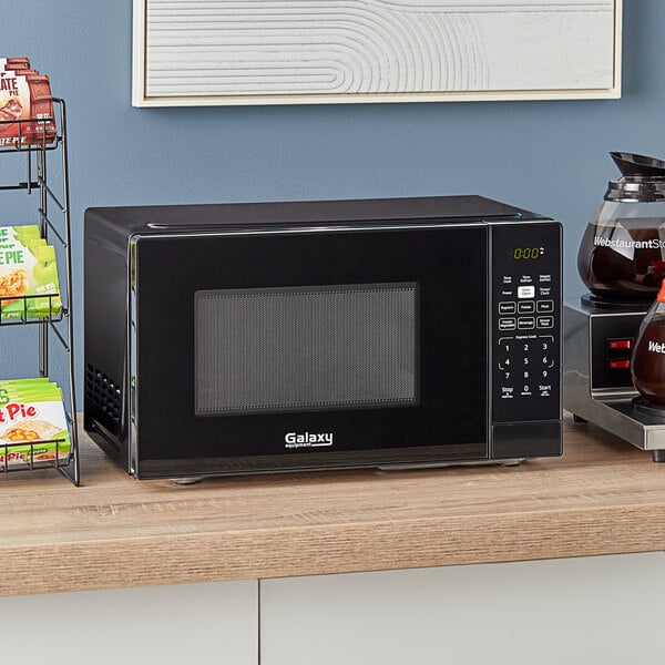 A black Galaxy office series microwave on a counter.