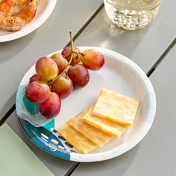 A Choice paper plate with grapes and cheese on a table