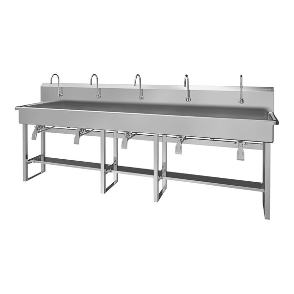 A large stainless steel floor-mounted multi-station sink with 5 knee-operated faucets.