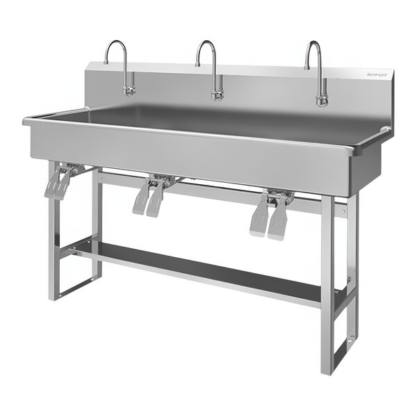 A Sani-Lav stainless steel floor-mounted multi-station utility sink with double knee-operated faucets.