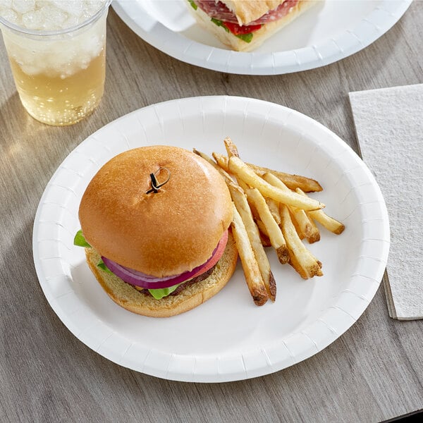 A Choice heavy weight white paper plate with a hamburger and fries on a table.