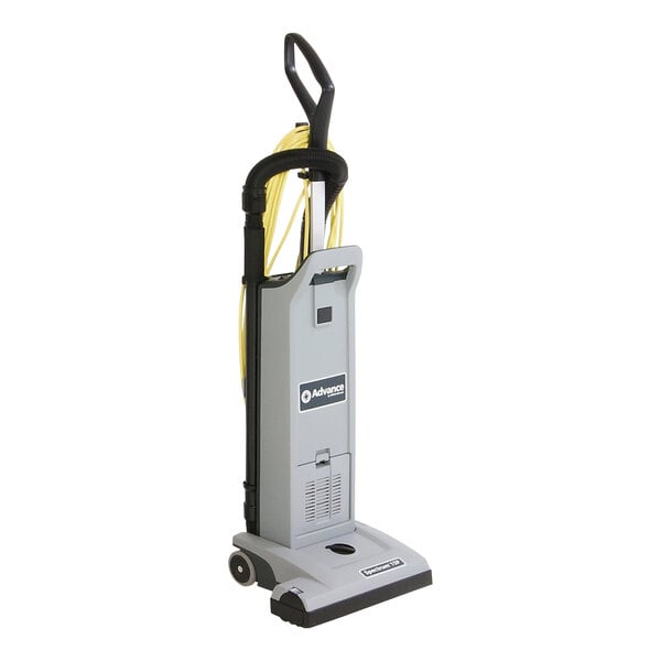 A grey vacuum cleaner with a yellow handle and black wheels.