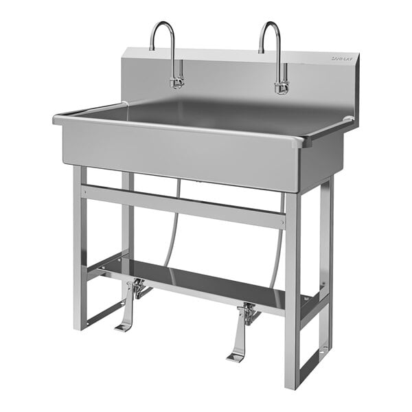 A Sani-Lav stainless steel floor-mounted utility sink with foot-operated faucets.