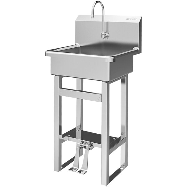 A large stainless steel Sani-Lav floor-mounted sink with double foot-operated faucets.