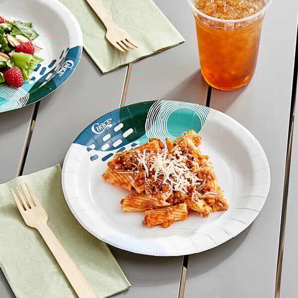 Two Choice heavy weight paper plates with pasta and a drink on a table.