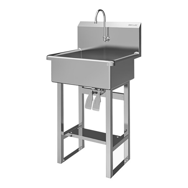A large stainless steel floor-mounted sink with double knee-operated faucets.