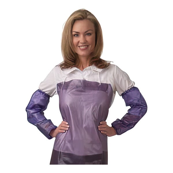 A woman wearing a purple shirt and a purple apron with her hands on her hips, wearing blue Cordova vinyl sleeves.
