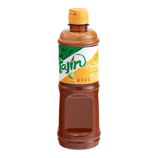 A close up of a bottle of Tajin Chamoy Hot Sauce with an orange label.
