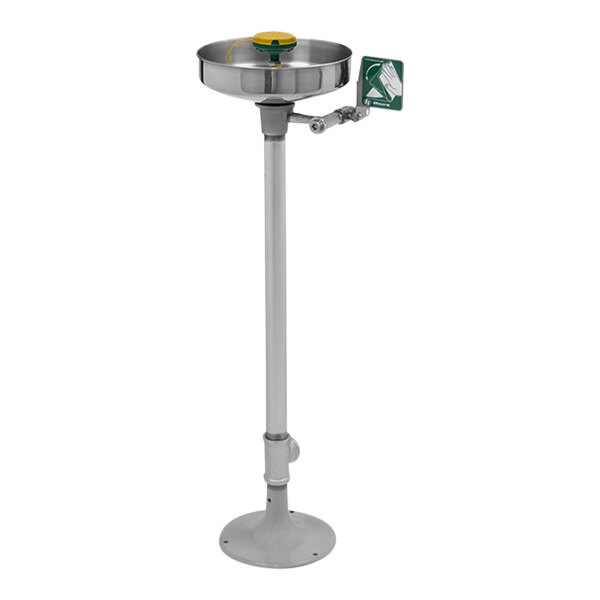 A white pole with a stainless steel and green Haws eye and face wash station.