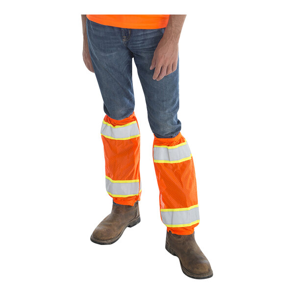 A person wearing Cordova Class E Hi-Vis orange and white reflective leg covers.