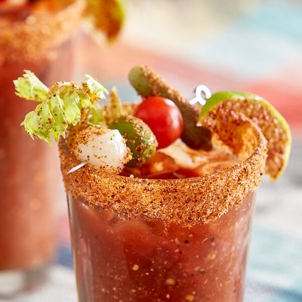 A bloody mary garnished with Tajin seasoning on the rim.