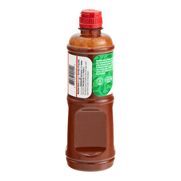 A close up of a Tajin Mild Hot Sauce bottle with a red cap.