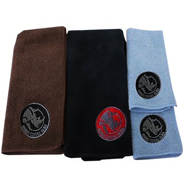 A set of three white bar towels with black and white Rhino Coffee Gear logos.