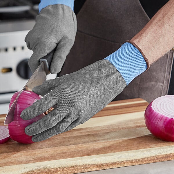 A person wearing Armor Guys Kyorene Pro cut-resistant gloves cutting an onion.