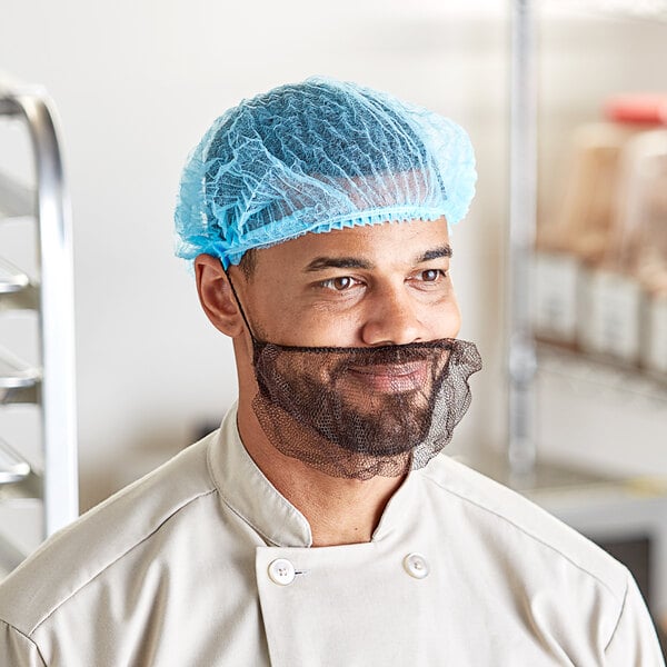 A man with a beard wearing a blue Choice polypropylene bouffant cap.