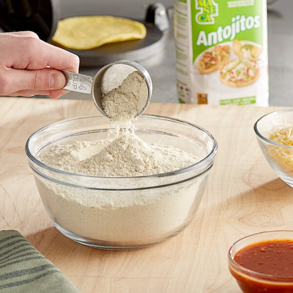 A bowl of Maseca Antojitos Corn Masa Flour being poured into a bowl.