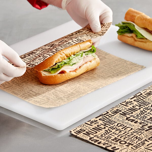 A gloved hand wraps a sandwich in Choice Kraft sandwich wrap.