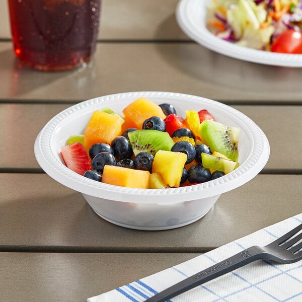 A bowl of fruit salad in a white bowl on a table.