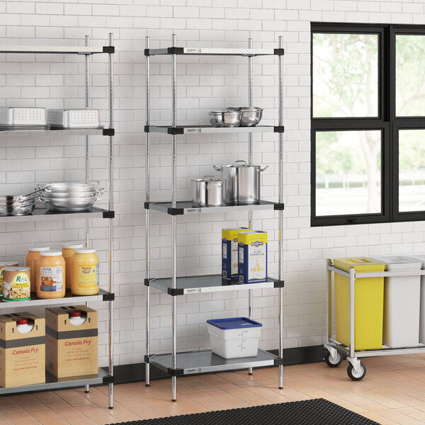 Regency galvanized steel shelves in a school kitchen with food containers on them.