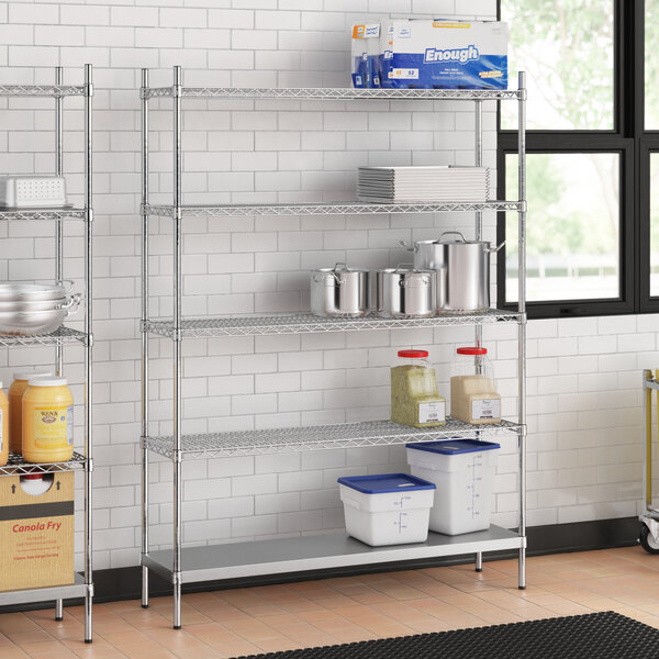 A stainless steel wire shelf kit with solid stainless steel shelves in a professional kitchen.