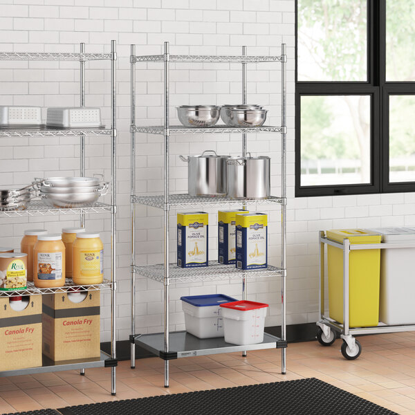 A Regency metal wire shelving unit with a solid metal bottom shelf holding containers.