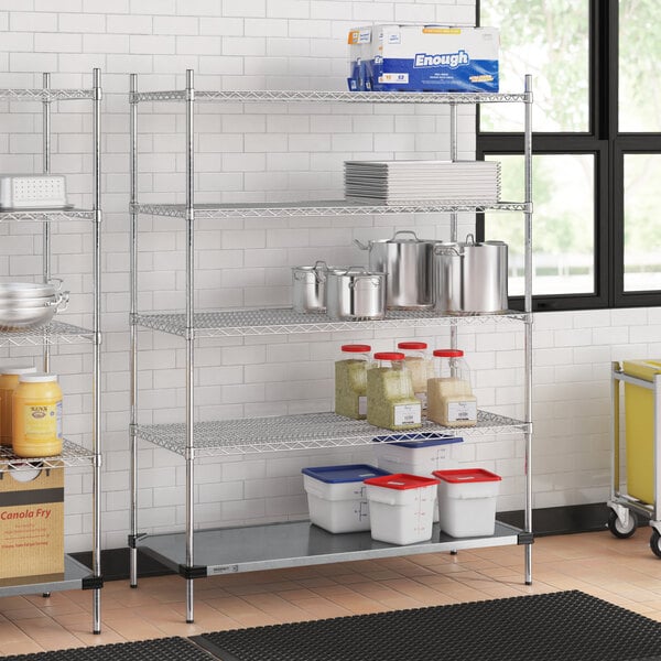 A Regency chrome wire shelving unit in a kitchen with white and blue plastic containers on it.
