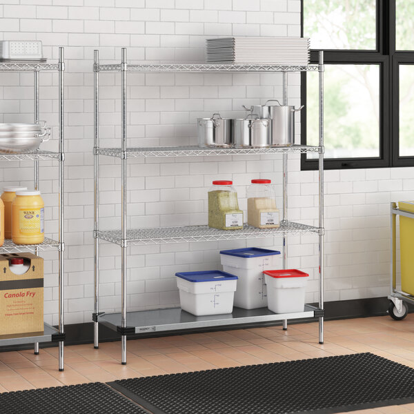 A Regency chrome wire shelving unit in a kitchen with white plastic containers on the bottom shelf.