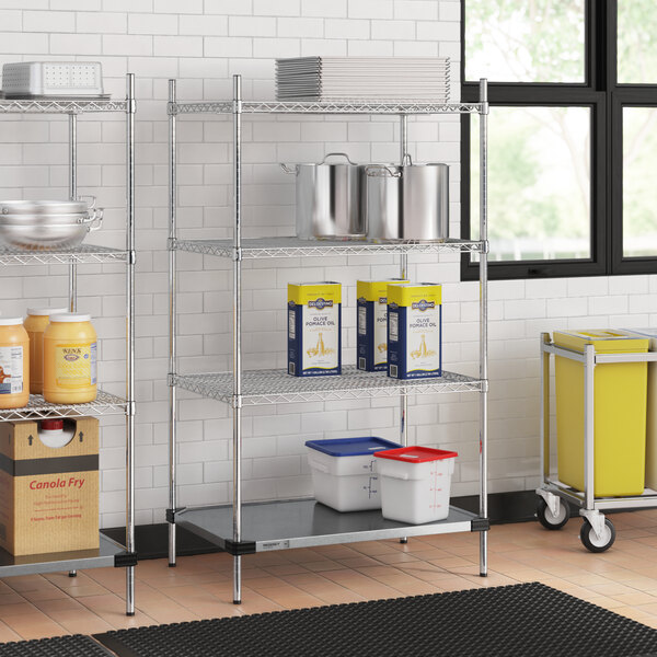 A Regency chrome wire shelving unit in a kitchen with white and blue plastic containers on the shelves.