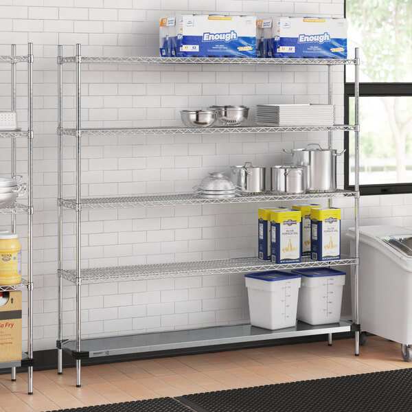 A Regency chrome wire shelving unit in a kitchen with a solid metal bottom shelf.