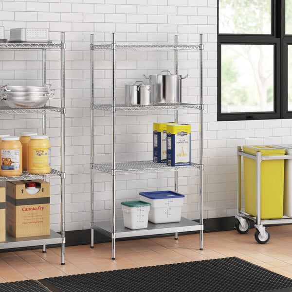A stainless steel wire shelf kit with solid stainless steel shelves in a school kitchen.