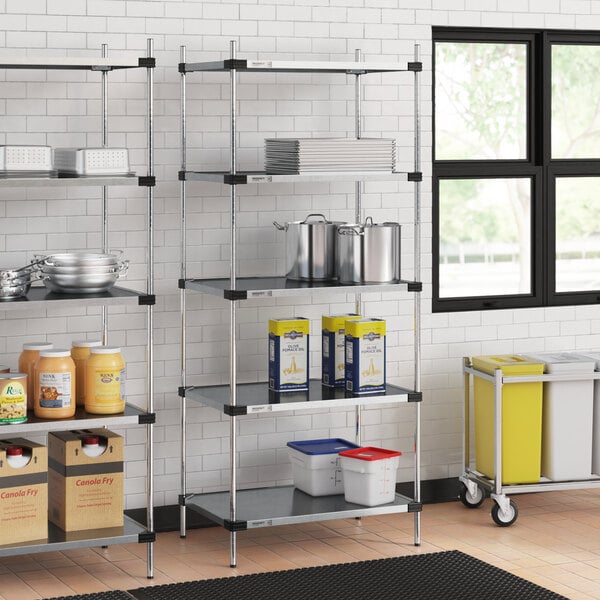 Regency galvanized steel shelves in a school kitchen with food items on them.