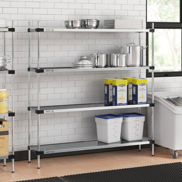 A Regency galvanized steel shelving unit in a professional kitchen with white containers.