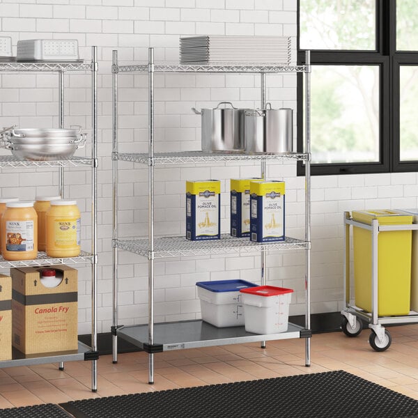 Regency chrome wire shelving unit in a kitchen with white and blue plastic containers on the shelves.