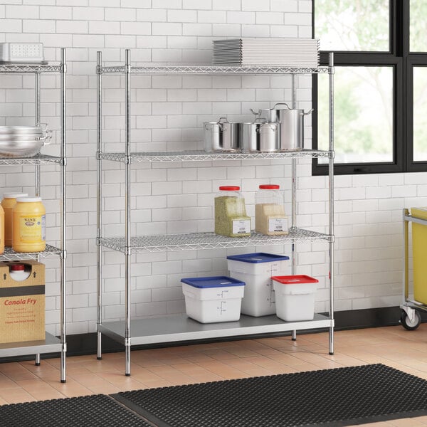 A stainless steel wire shelf unit with solid stainless steel shelves holding containers.