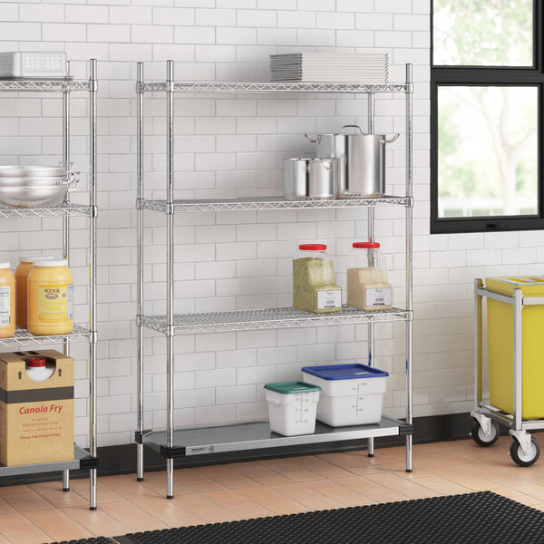 A Regency chrome wire shelving unit in a kitchen with white and blue plastic containers on the shelves.