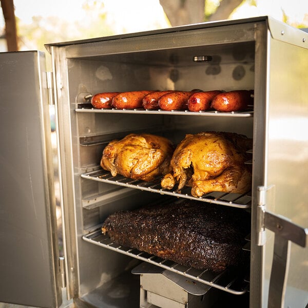 A SmokinTex 1400 Pro Series electric smoker with meat and sausages on the rack.