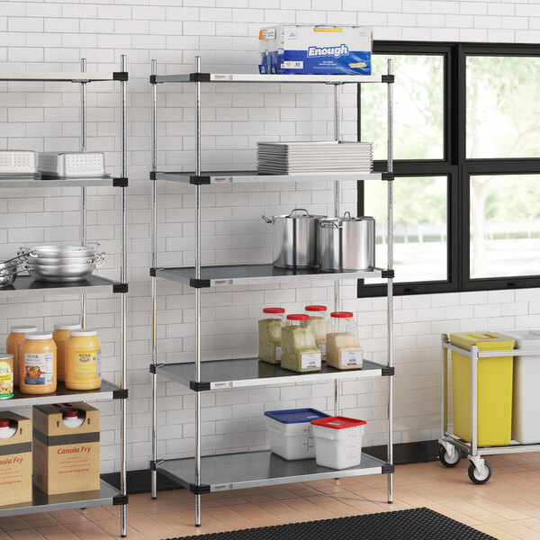 Regency galvanized steel shelves in a school kitchen with food items on them.