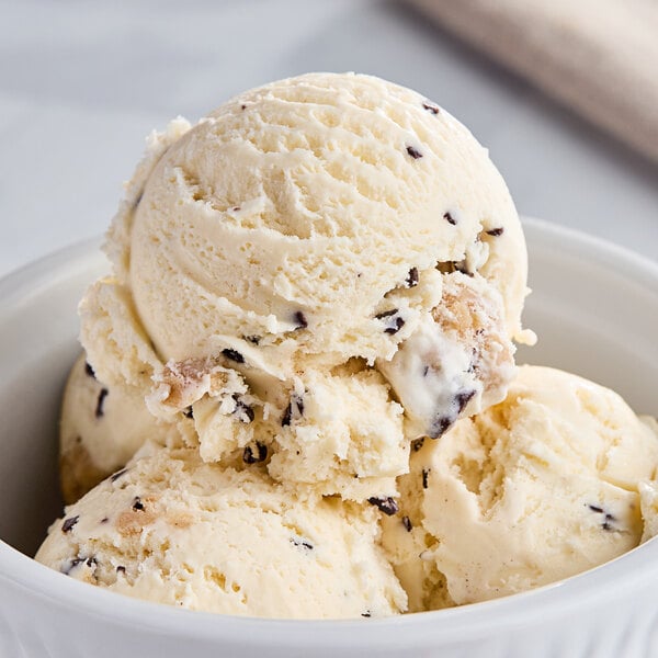A bowl of Tillamook Chocolate Chip Cookie Dough ice cream with a scoop on top.