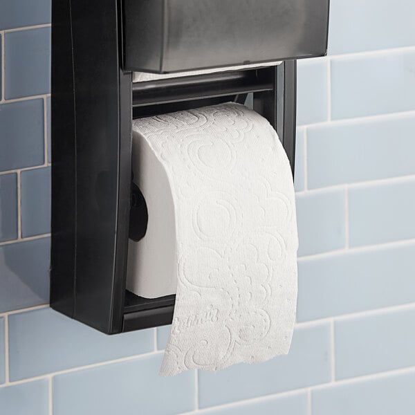 A black toilet paper dispenser with a mega roll of Charmin Ultra Soft toilet paper on it.