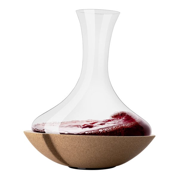 A Vacu Vin glass carafe filled with red wine on a table.