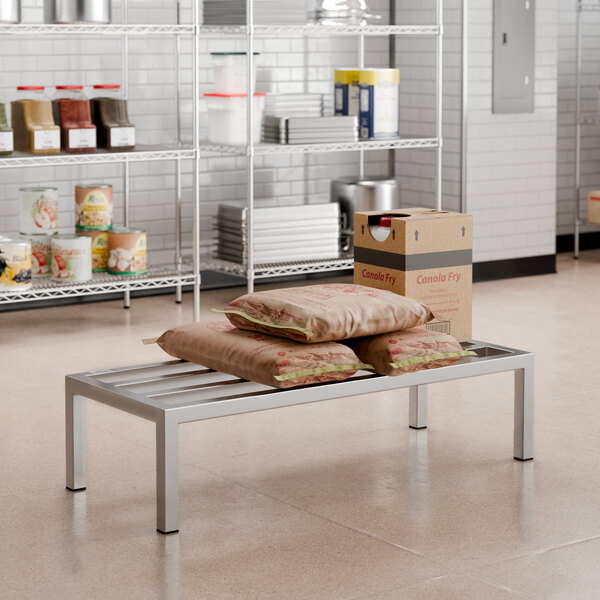 A stainless steel Regency dunnage rack shelf holding bags and boxes.