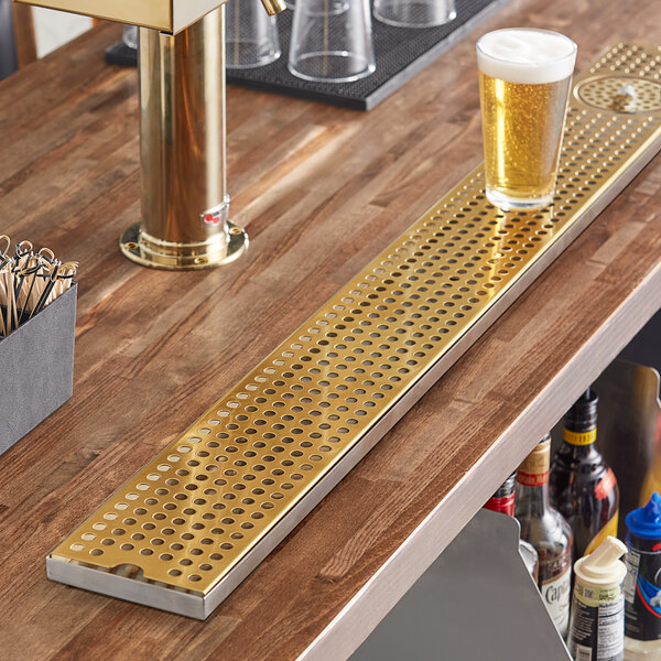 A Regency surface-mount beer drip tray with a glass of beer on it.