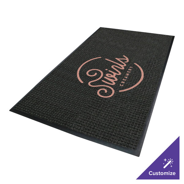 A rectangular black mat with a textured surface, featuring a circular logo and text in the center, bordered by a solid black edge.